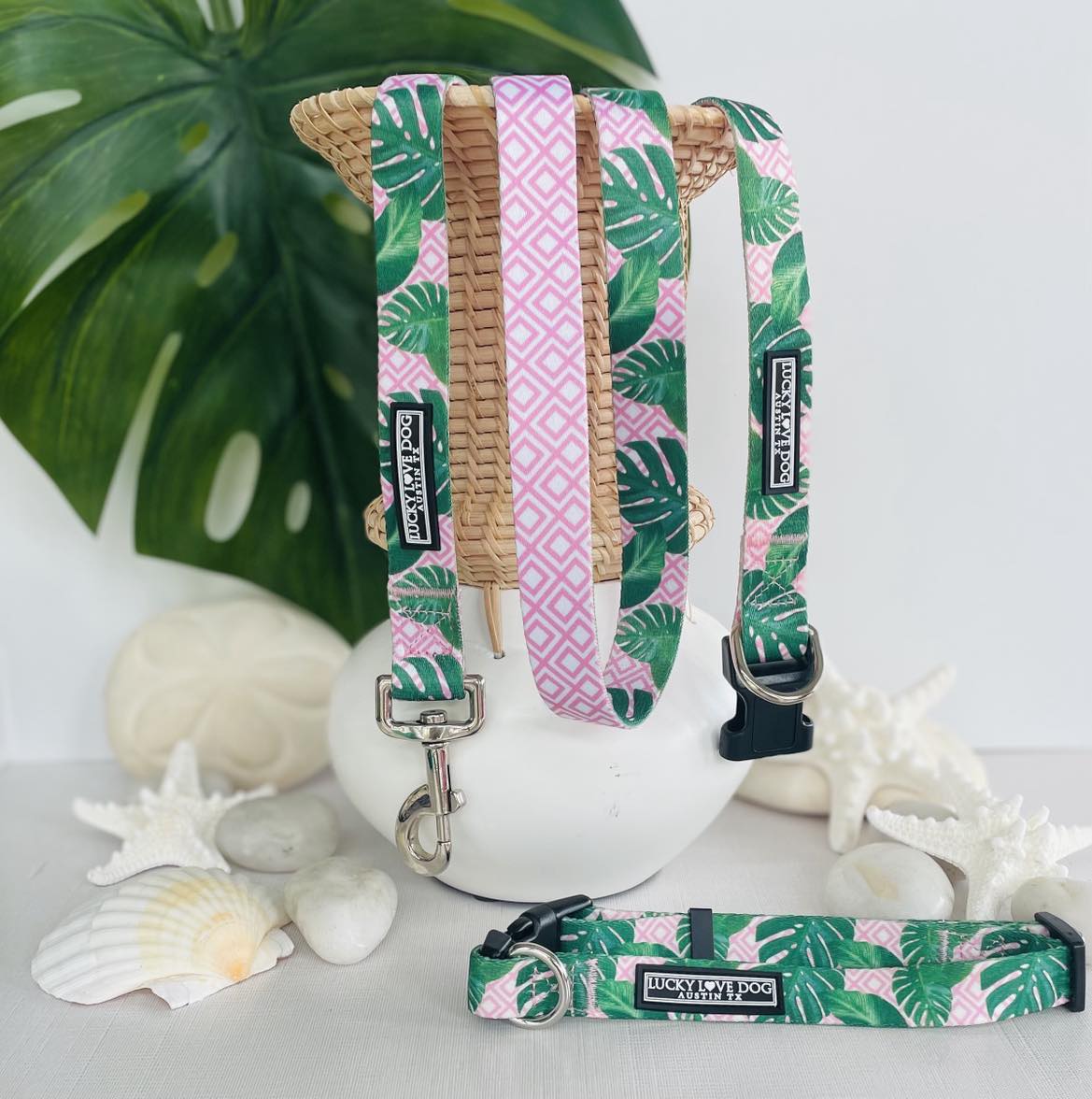 Tropical-themed dog collars and leash with green monstera leaves and pink geometric patterns