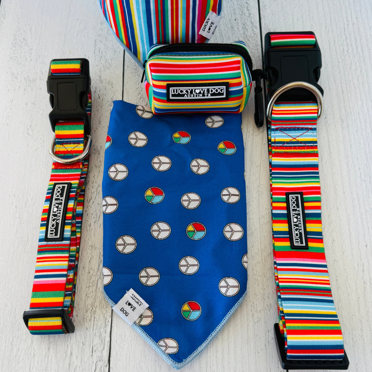 Hippie bandana for dogs showing the blue retro peace sign pattern side, displayed next to matching rainbow striped dog collars and a pouch with the product description page.
