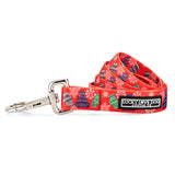 Red winter-themed dog leash by Lucky Love Dog Austin featuring mittens, hats, and snowflake patterns.