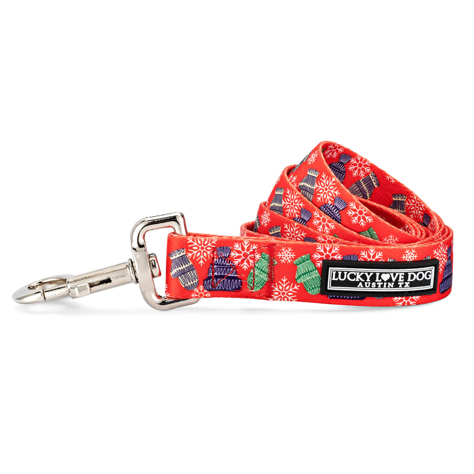 Red winter-themed dog leash by Lucky Love Dog Austin featuring mittens, hats, and snowflake patterns.