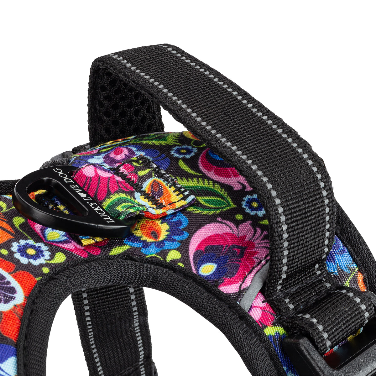 Close-up of a floral dog harness highlighting the black padded top control handle and durable metal leash attachment ring.