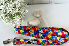 Bright blue dog leash with a colorful floral pattern, displayed with white stones and flowers.