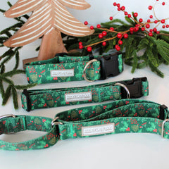 Green holiday-themed Lucky Love Dog collars displayed with festive greenery and decorative accents.
